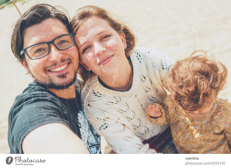 Junge Familie posiert zusammen für ein Selfie in ihrem Urlaub jung Fröhlichkeit Liebe Feiertage Baby Eltern Elternschaft Lächeln Spaß lustig Freude genießen