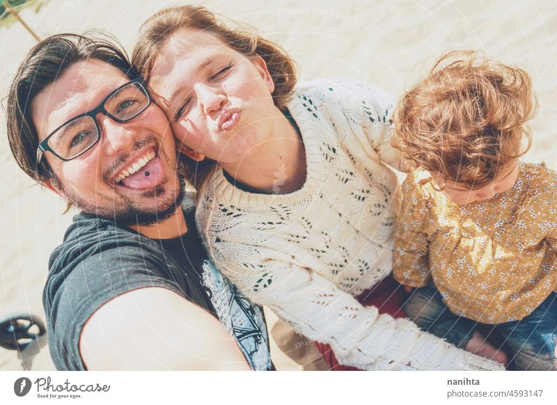 Junge Familie posiert zusammen für ein Selfie in ihrem Urlaub jung Fröhlichkeit Liebe Feiertage Baby Eltern Elternschaft Lächeln Spaß lustig Freude genießen