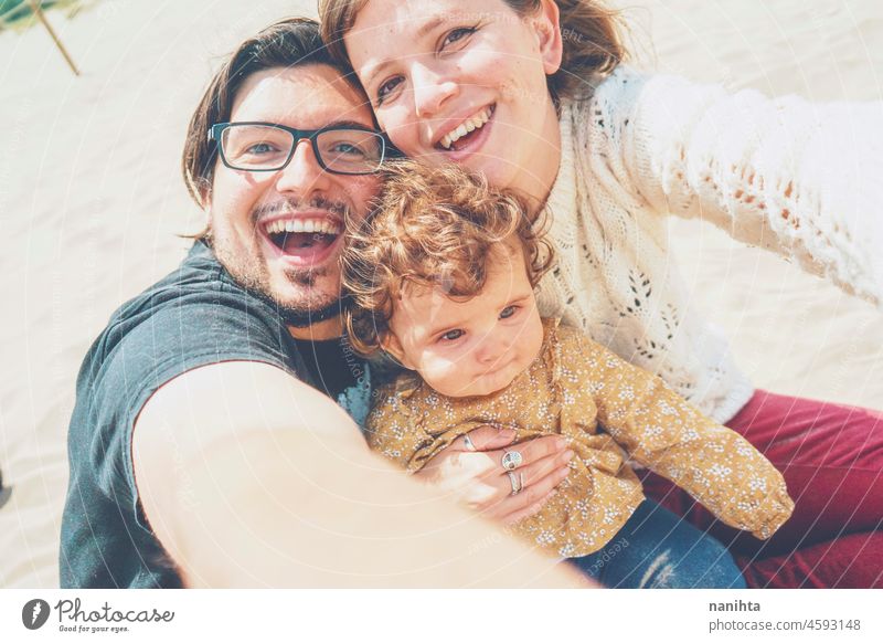 Junge Familie posiert zusammen für ein Selfie in ihrem Urlaub jung Fröhlichkeit Liebe Feiertage Baby Eltern Elternschaft Lächeln Spaß lustig Freude genießen