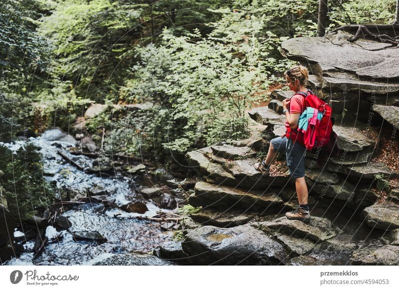 Frau mit Rucksack beim Wandern in den Bergen. Frau macht Pause auf einem Felsen sitzend Abenteuer Ausflug reisen wandern Urlaub Trekking Sommer aktiv Reise