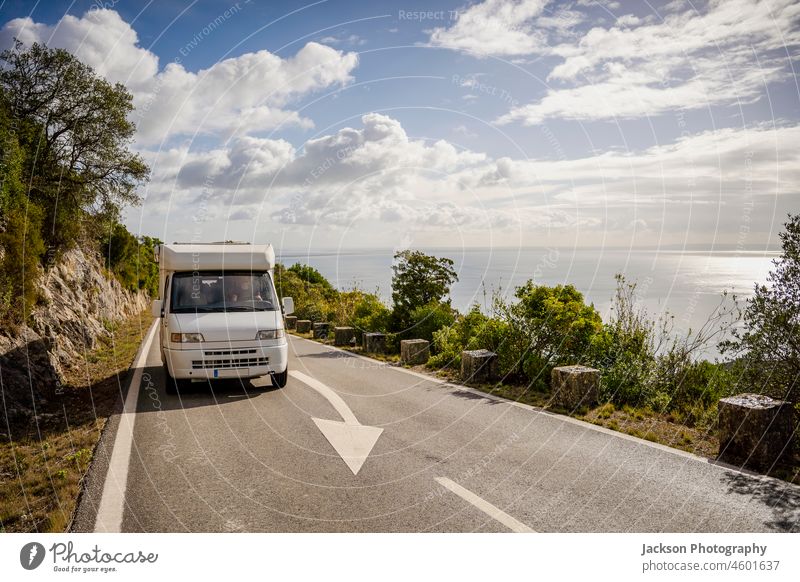 Kleines Wohnmobil auf einer landschaftlich reizvollen Straße mit Meerblick im Naturpark Arrabida, Portugal rv Ausflug ländlich Lifestyle Strandpromenade Park