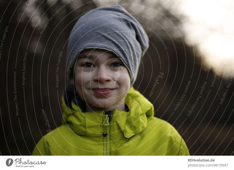 Junge mit Mütze lächelt Kind Mensch Kindheit Umwelt Jacke Lächeln natürlich klein Zufriedenheit Freizeit & Hobby Blick nach vorn Blick in die Kamera Porträt