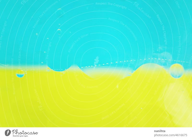 Eine schöne und bunte Makro von Ölblasen auf dem Wasser mit zwei Farbe als hohen Kontrast Hintergrund, blau und gelb abstrakt Erdöl Tapete Schaumblase Ressource