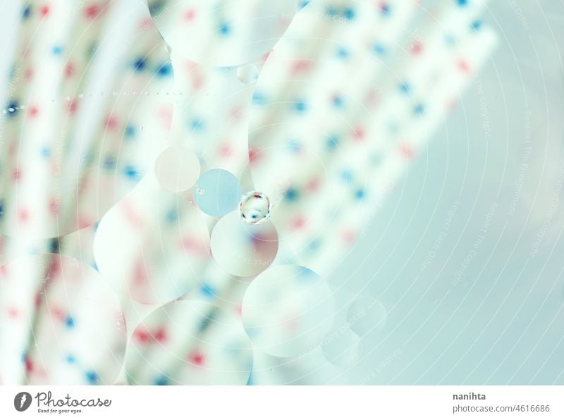 Eine schöne und bunte Makro von Ölblasen auf dem Wasser mit Unschärfe von roten und blauen Punkten auf weißen Strohhalmen als Hintergrund mit Vintage-Filter