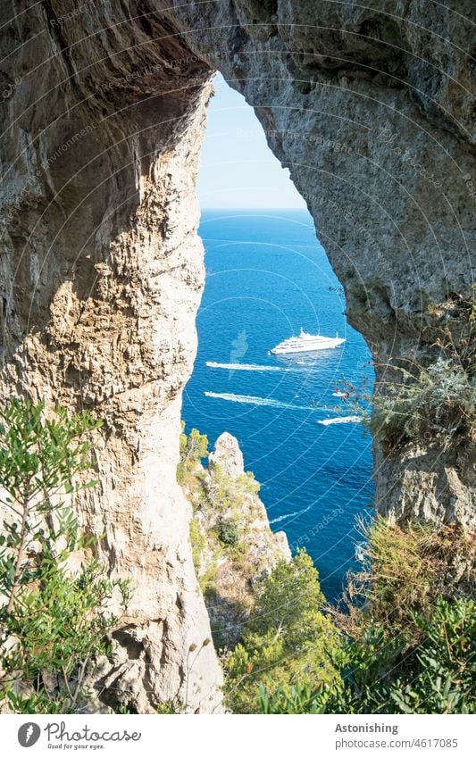 Natürliches Tor zum Meer Landschaft Natur Spalt Arco Naturale Capri Mittelmeer Boot Boote Schiffe Felsen Steine Steinformationen Grün Blau Horizont steil hoch