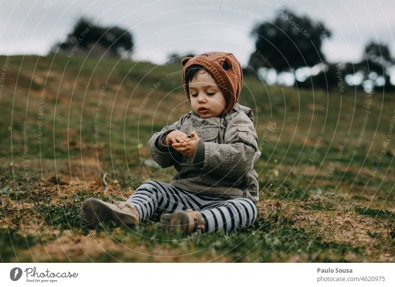 Kind mit Kapuzenjacke beim Spielen im Freien Kindheit Junge 1-3 Jahre Kaukasier echte Menschen Winter Herbst authentisch Kapuzenpullover Außenaufnahme Farbfoto