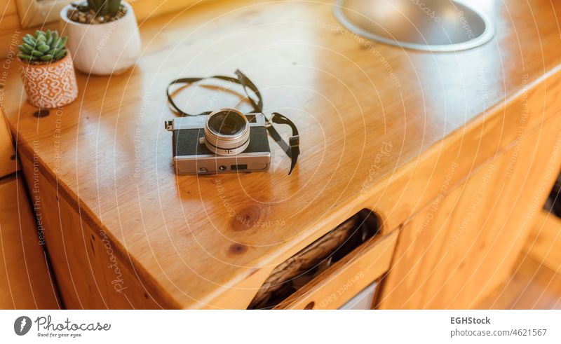 Alte analoge Fotokamera auf dem Tisch eines Wohnmobils, bereit für den Start des Roadtrips Holztisch Kleintransporter Urlaub reisen Gedächtnis Spaß Autoreise