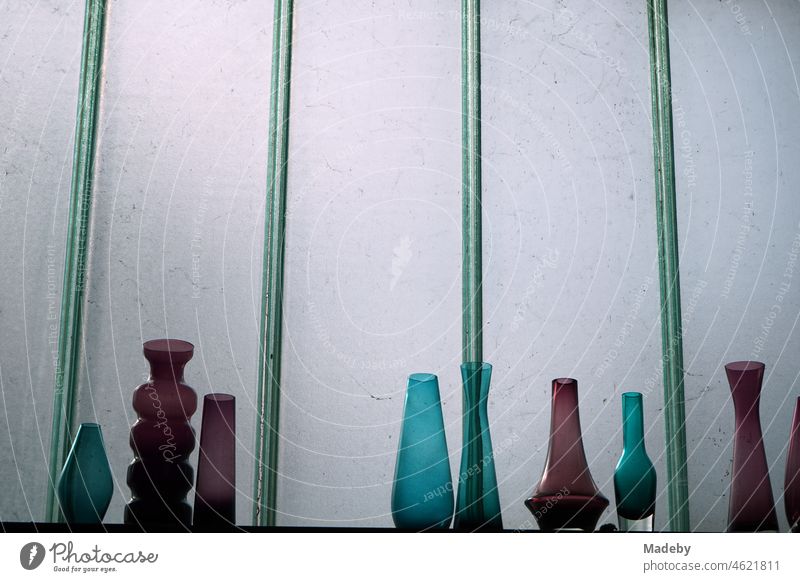 Bunte Designer Vasen aus Glas im Stil der Sechzigerjahre und Siebzigerjahre vor einer Scheibe aus Milchglas in einer alten Werkstatt im Stadtteil Margaretenhütte in Gießen an der Lahn in Hessen