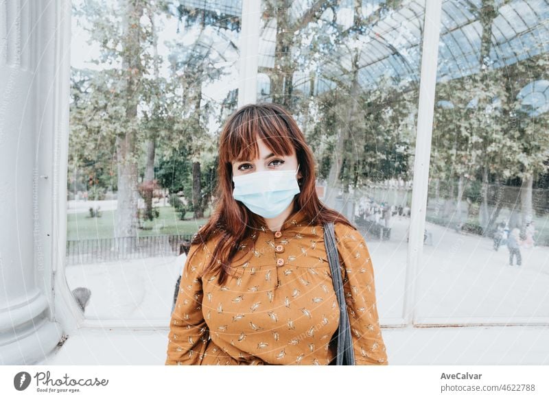 Junge Frau mit einer Gesichtsmaske, die sie vor Covid und anderen Viren, Grippe und Gesundheitsproblemen schützt. Schutz im Freien während einer Pandemie. Hipster und modernen Stil, junge Studentin.