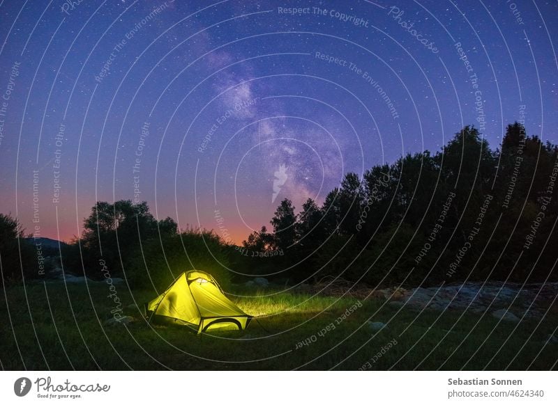 beleuchtetes gelbes Zelt in der Dämmerung mit Milchstraße am Himmel Landschaft Nacht Natur Galaxie Stern reisen Baum Licht im Freien Raum dunkel Hintergrund
