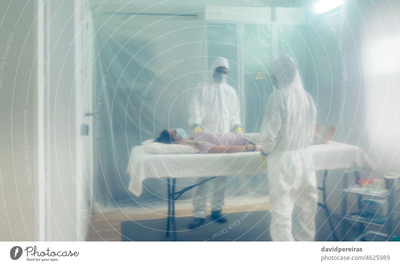 Ärzte in einem Feldlazarett mit einer verstorbenen Person auf einer Bahre Feldkrankenhaus covid-19 Verstorbener Frau unkenntlich Coronavirus Virus Arzt