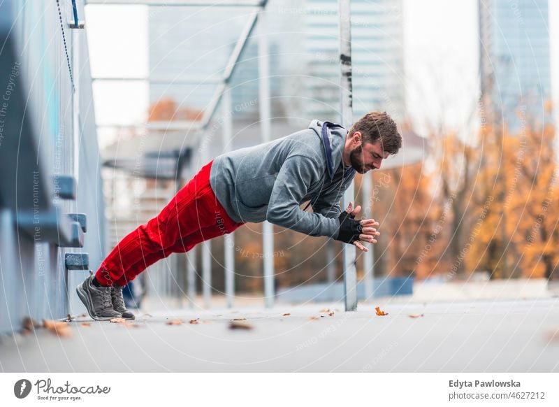 Junger Mann beim Sport in einer städtischen Umgebung Menschen kalte Witterung Herbst Sportler Stärke Motivation Tatkraft eine Person Bodybuilding Energie