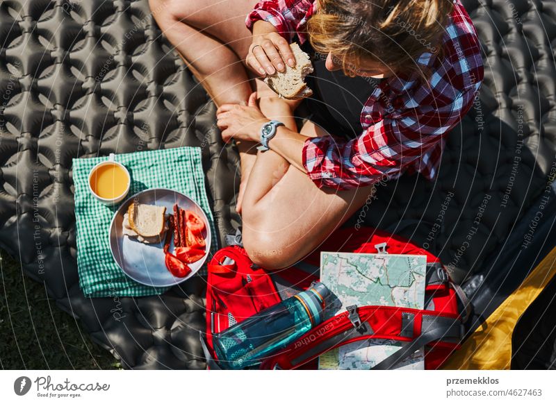 Frau frühstückt beim Zelt auf dem Campingplatz. Weibliche aktiv verbringen Sommerferien in der Nähe der Natur im Freien Urlaub Ausflug Abenteuer Frühstück