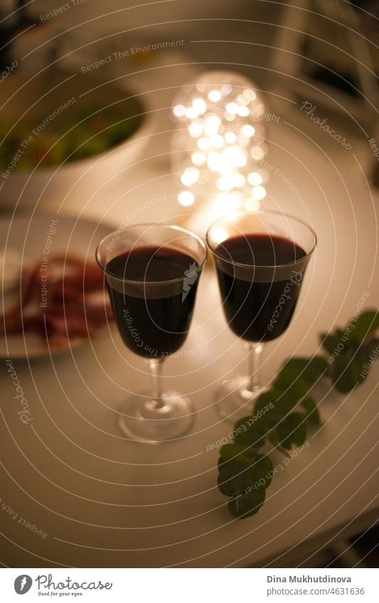 Zwei Gläser Rotwein mit Aperitifs bei einem romantischen Date bei Kerzenschein und festlicher Beleuchtung Wein Glas trinken Alkohol Tisch rot weiß Restaurant