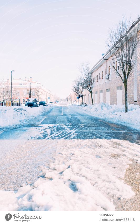 Eine vereiste Straße nach starkem Schneefall mit Autos, die unter dem Schnee begraben sind. Wintersaison. Fokus auf die Straße Automobil Schneesturm vergraben