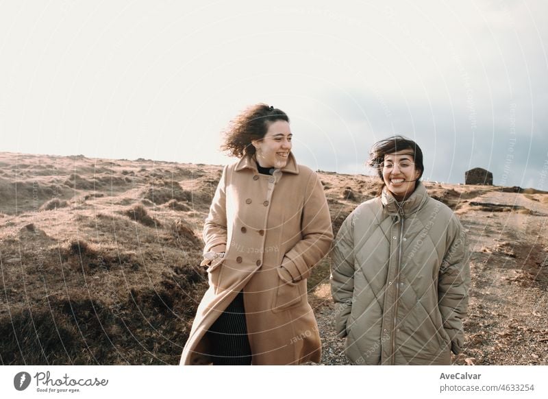 Junge Frau Zwei Freunde auf der Wiese Lachen und Wandern während eines bunten Sonnenuntergangs. Kopieren Raum, Film-Konzept. Freundschaft und Reisen zusammen Road Trip Stil Bild. Normale Menschen