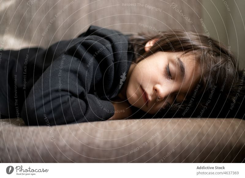 Niedlicher ethnischer Junge schläft auf der Couch Kind schlafen Mittagsschlaf müde schlafend Liege Kindheit Wohnzimmer Schlafenszeit ruhen heimwärts Müdigkeit