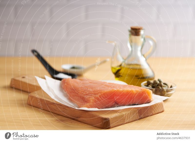 Roher Fisch auf einem Holzbrett mit Zutaten Lachs roh Filet Lebensmittel Bestandteil Küche Koch kulinarisch Gewürz Schiefer Rezept Meeresfrüchte vorbereiten