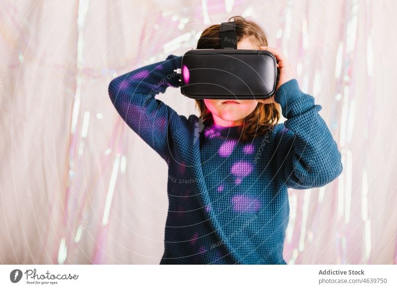 Mädchen erkundet den Cyberspace mit VR-Brille Kind Virtuelle Realität erkunden Erfahrung Schutzbrille Headset virtuell neonfarbig Apparatur Gerät Innovation