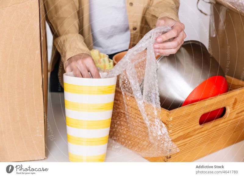 Erntehelfer beim Auspacken von Küchengeräten während des Umzugs Person Hausbesitzerin untersuchen Tisch verlegen heimwärts auspacken Kasten heimisch