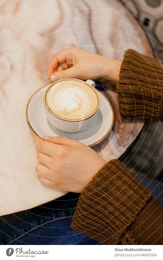 Frau trinkt Kaffee - Hände halten eine Tasse Cappuccino in einem Café auf einem Marmortisch Koffein Murmel Schreibtisch liquide Textfreiraum Kaffeetasse Pause