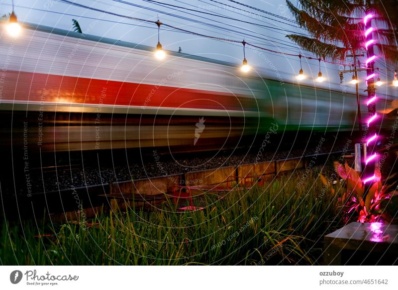 Der Personenzug fährt bei Sonnenuntergang schnell. unterwegs. Zug Verkehr Bewegung Geschwindigkeit Eisenbahn bewegend Station Transport Lokomotive Linie Schiene