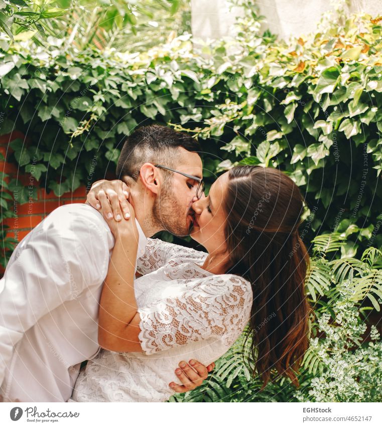 Newlywed Paar küssen und tanzen an ihrem Hochzeitstag. Frau trägt eine schöne Spitze Hochzeit Strumpfband.Union und Liebe Konzept. Küssen Tanzen umarmend Satin