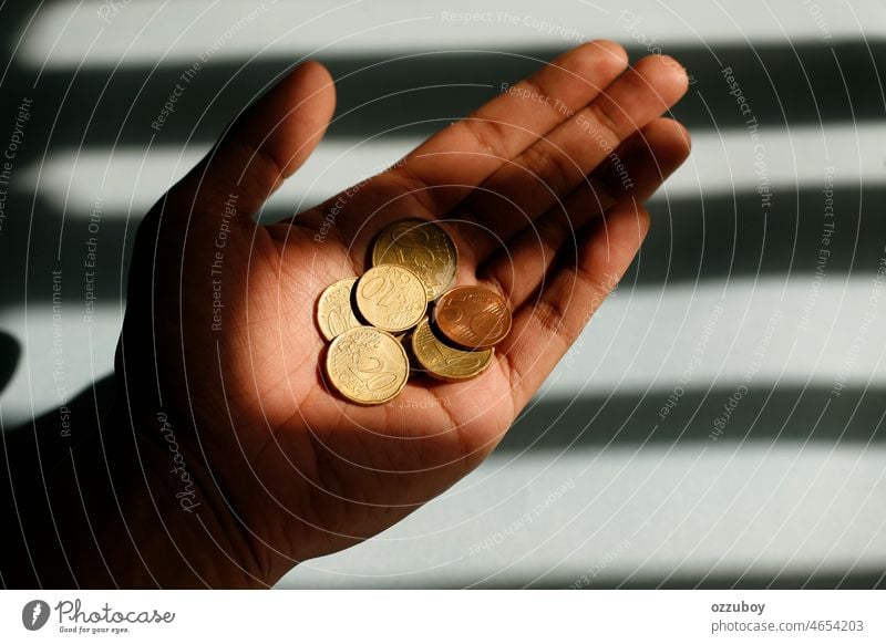 Close up Hand hält Euro-Cent-Münze mit Licht und Schatten-Muster als Hintergrund. Finanz-Konzept. Geldmünzen Währung Bargeld Finanzen Beteiligung Investition