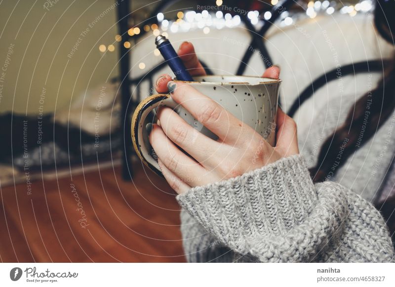 Frau hält eine warme Tasse Kaffee in den Händen Tee Herbst Töne Licht Bokeh Wolle Wollstoff Pullover heimwärts jung Jugend Halt Beteiligung schwarz Wärme