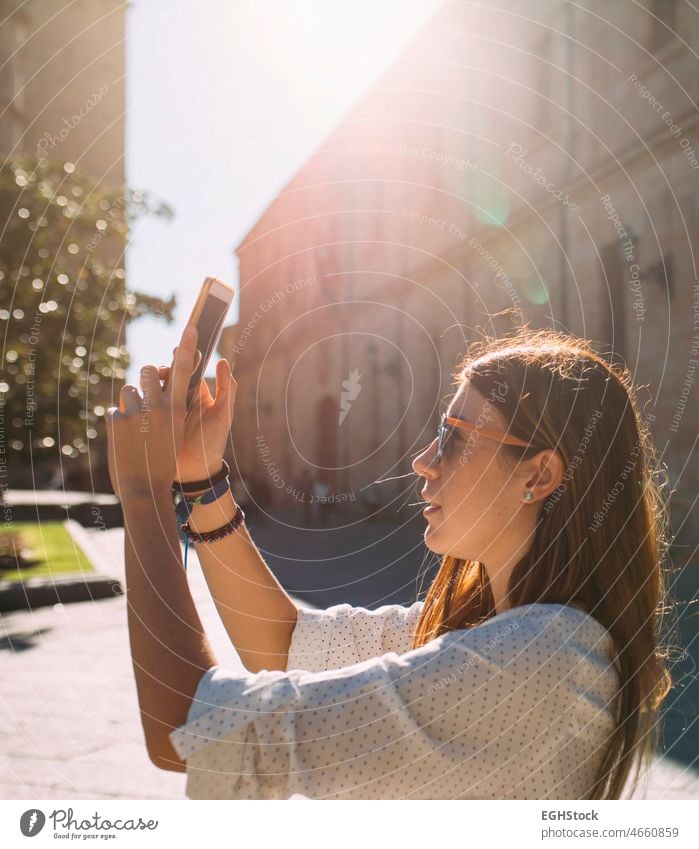 Junge Frau, die eine antike Stadt in Spanien besucht, fotografiert mit ihrem Handy bei Sonnenuntergang ein Denkmal in Salamanca besuchen eine Person historisch