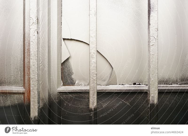 vergittertes Fenster mit kaputter Scheibe, silber und schwarz angesprayt Glasscheibe sprayen Gebäude Zerstörung Vergänglichkeit Fensterscheibe
