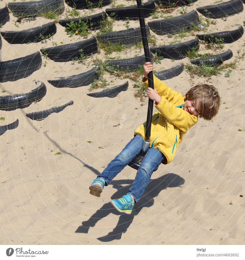 Schaukelspaß - Kind schaukelt im Sonnenlicht auf einer Riesenschaukel , Schatten im Sand Mensch Junge Kindheit Freude Spaß schaukeln Spielen Spielplatz