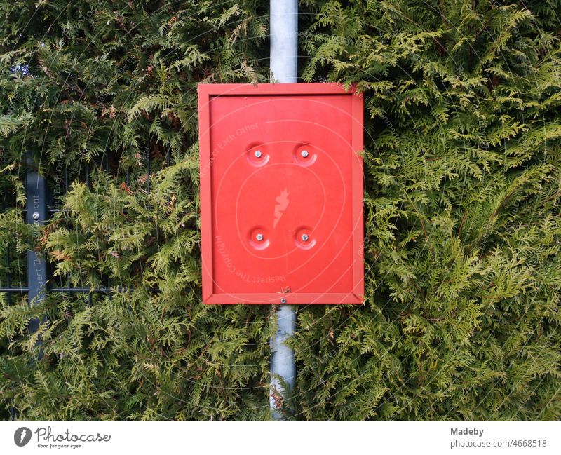 Leere rote Plastiktafel vor Grüne Hecke an einer verwaisten Bushaltestelle in Oerlinghausen bei Bielefeld am Hermannsweg im Teutoburger Wald in Ostwestfalen-Lippe