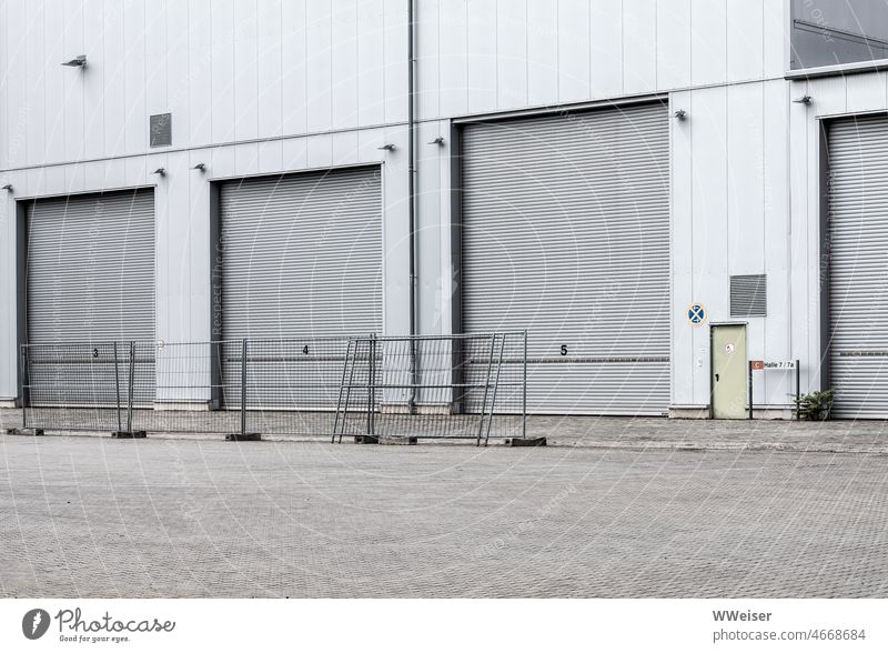 Verschieden große Einfahrten auf einem Industriegelände, davor stehen Zäune Zaun urban Stadt Großstadt Hafen Produktion Garage Fahrzeug Lager Tor geschlossen