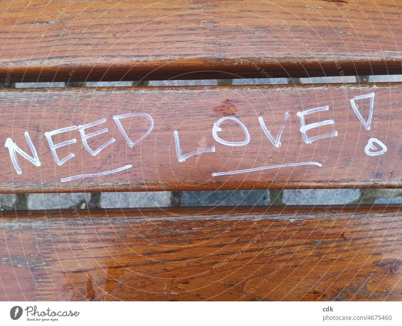 NEED LOVE! Schriftzug Parkbank Ausrufezeichen Unterstriche Graffiti Aussage Information Großbuchstaben englisch beschriebene Sitzfläche Zeichen "brauche Liebe!"