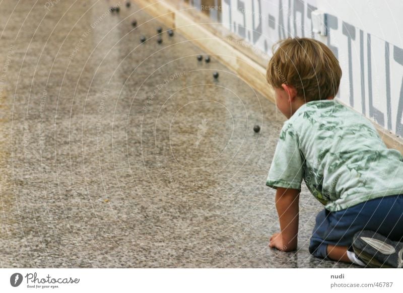 Faszination Kugel Kind Junge Spielen T-Shirt blond Wand Venedig Freude Bodenbelag auf den knien kunst bienale boy play fun Rückansicht