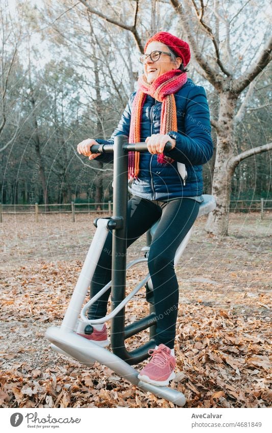 Alte Frau, die im Park an den Geräten trainiert, um die Gelenke gut zu halten. Glücklich mit gesundem Leben. Sport in der Natur für ältere Menschen. Arme und Beine Konditionierung für geriatrische