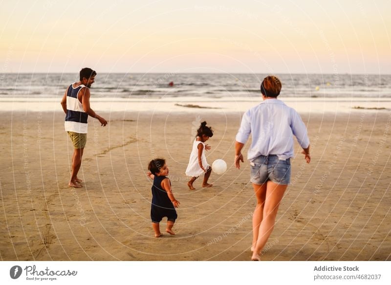 Fröhliche, bunt gemischte Familie spielt mit Ball am Strand Vater Mutter multiethnisch Kinder Junge Mädchen Sohn spielen Spiel Schwester Spaß haben