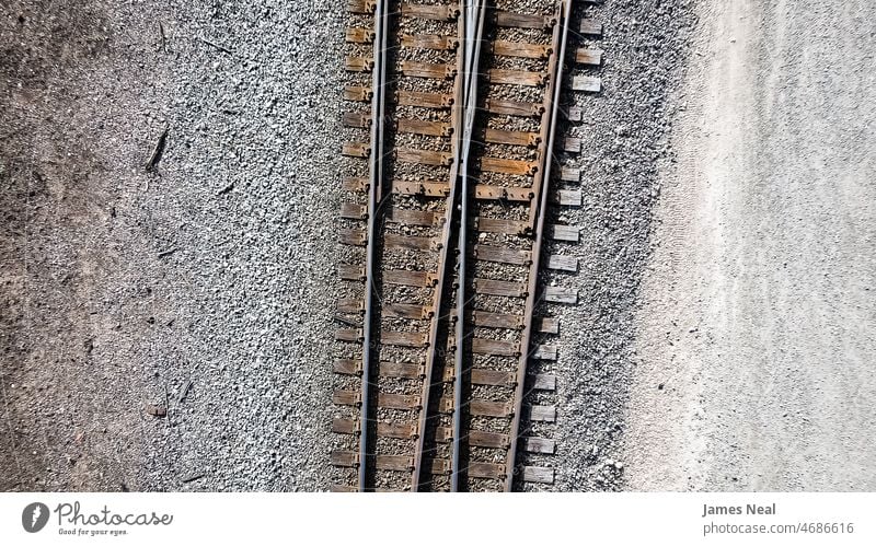 Luftaufnahme von zwei alten, rostigen Eisenbahnschienen. Bahn Oberfläche Kies industriell Industrie Verkehr Boden Spuren flach Ansicht oben Grunge Straße