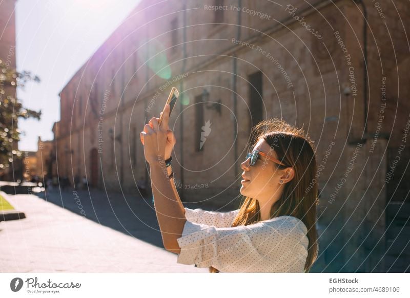 Junge Frau, die eine antike Stadt in Spanien besucht, fotografiert mit ihrem Handy ein Denkmal in Salamanca eine Person besuchen Fundstück historisch Tourismus