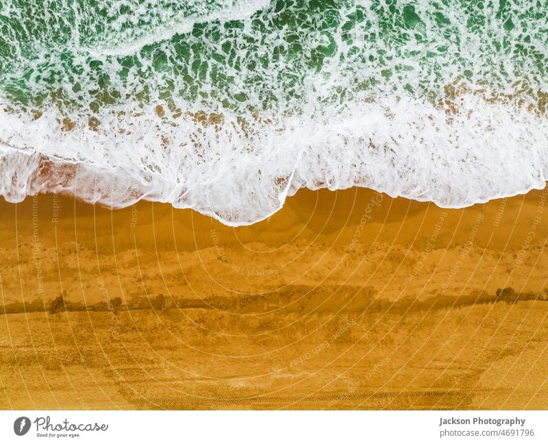 Draufsicht auf Wellen, die am Sandstrand von Albufeira, Algarve, Portugal, brechen Meer Strand Natur Textfreiraum pulsierend im Freien Naturhintergrund sandig