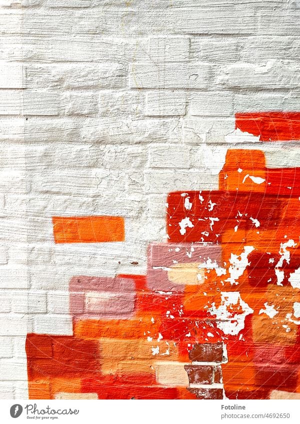 Orange, rosa, braune und rote Farbe auf weiß gestrichenen Ziegeln. Außenaufnahme Wand Farbfoto Fassade orange Mauer Kunst Malerei farbig bunt