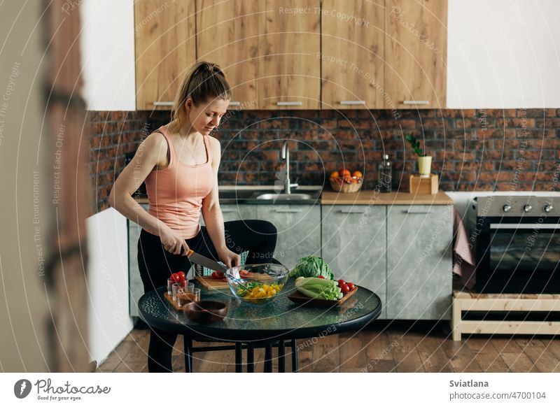 Sportliche Frau kocht gesundes Essen zu Hause Salatbeilage Gesundheit Sellerie Paprika heimwärts Lifestyle Küche Veganer Diät Gemüse Essen zubereiten Tisch