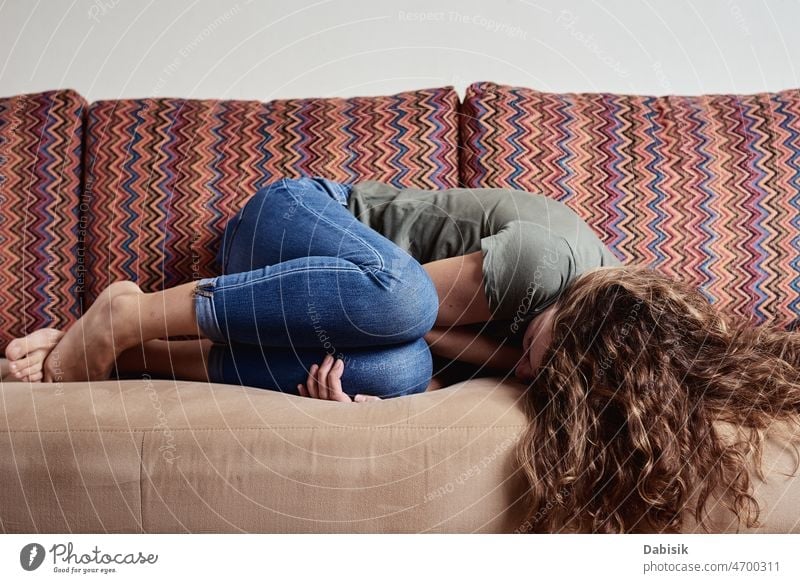 Auf dem Sofa liegende Frau mit Unterleibsschmerzen Schmerz Depression abdominal Darm Frauen Problematik Stress Obstipation wehtun Zeitraum Schmerzen Gesundheit