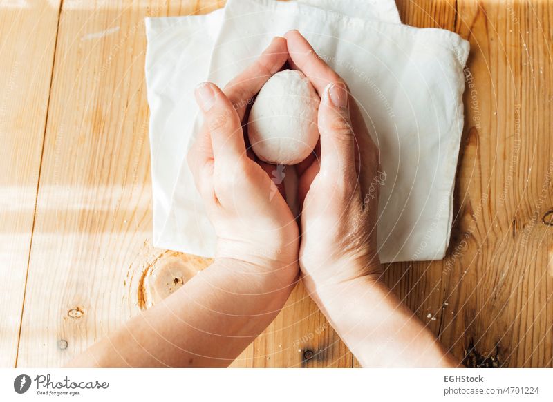 weibliche Hände halten ein handgefertigtes Keramik Ei für Ostern. Minimalistisch und diy Konzept. Frau eine Person Draufsicht minimalistisch Minimalismus Zement