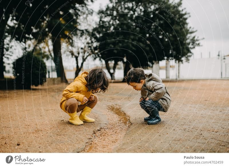 Bruder und Schwester spielen im Freien Regen regnerisch Geschwister Kind Kindheit 1-3 Jahre 3-8 Jahre Gummistiefel Fröhlichkeit Freizeit & Hobby Spielen