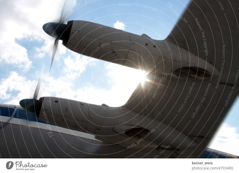 Tragfläche am Flugzeug einer Propellermaschine im Gegenlicht der Sonne Propellerflugzeug propellerflügel Triebwerk Maschine Flughafen Sonnenlicht Flugtechnik