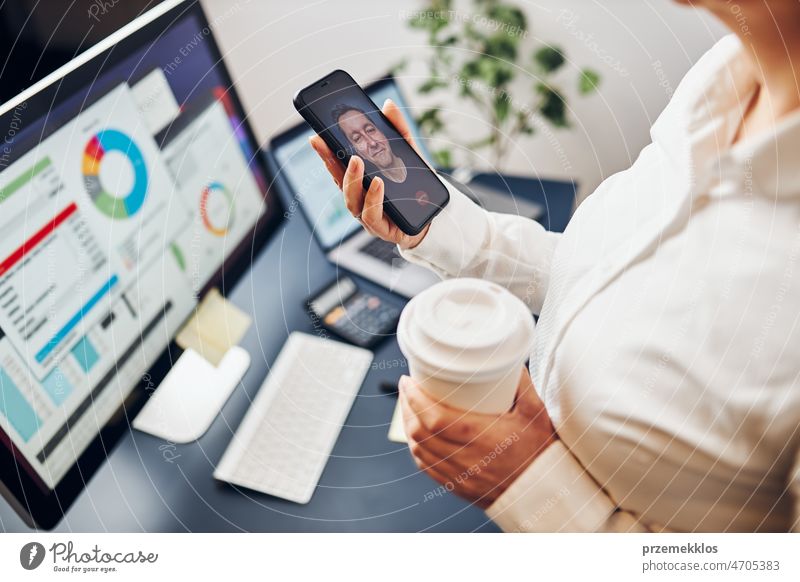 Geschäftsfrau im Videochat auf dem Handy mit ihrem Kollegen. Geschäftsfrau arbeitet mit Daten in Diagrammen, Grafiken und Diagrammen auf dem Computerbildschirm