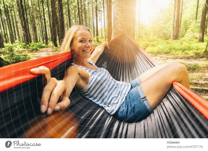 Fröhliche Frau genießen in einer Hängematte im Wald. Outdoor-Reise-Konzept-Bild sich[Akk] entspannen Sommer Camping Wanderer Komfort im Freien Mädchen reisen