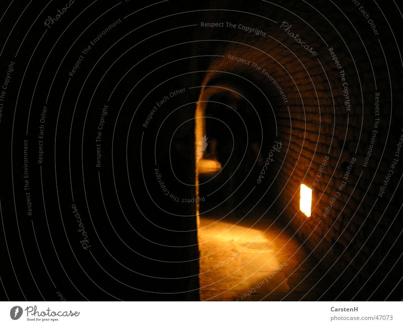 Im Tunnel dunkel Licht Prag Terezín Ghetto Angst Jüdisches Viertel Beleuchtung scheinend Lichterscheinung Gewölbebogen Menschenleer spukhaft gruselig